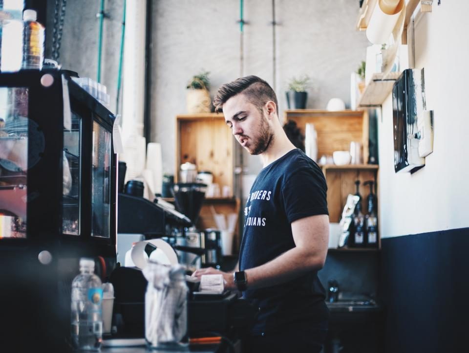 A coffee shop owner working behind his counter